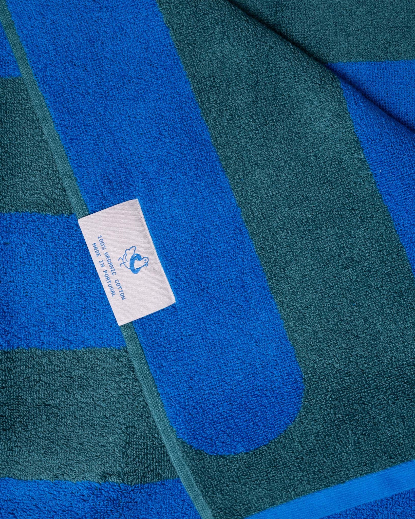 An image of a corner of a blue and green striped towel. 