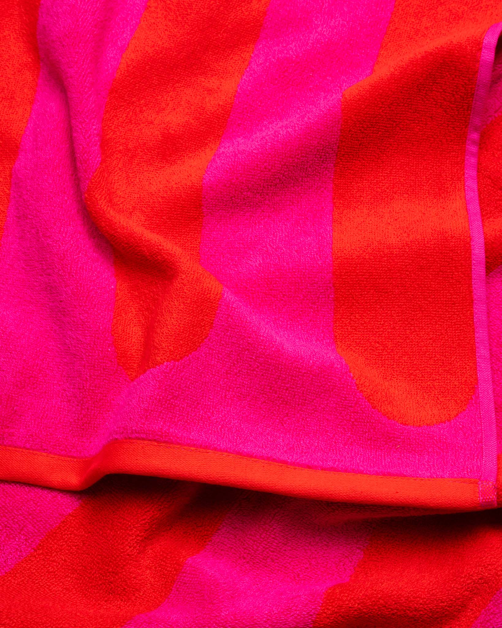 A folded red and magenta striped towel. 