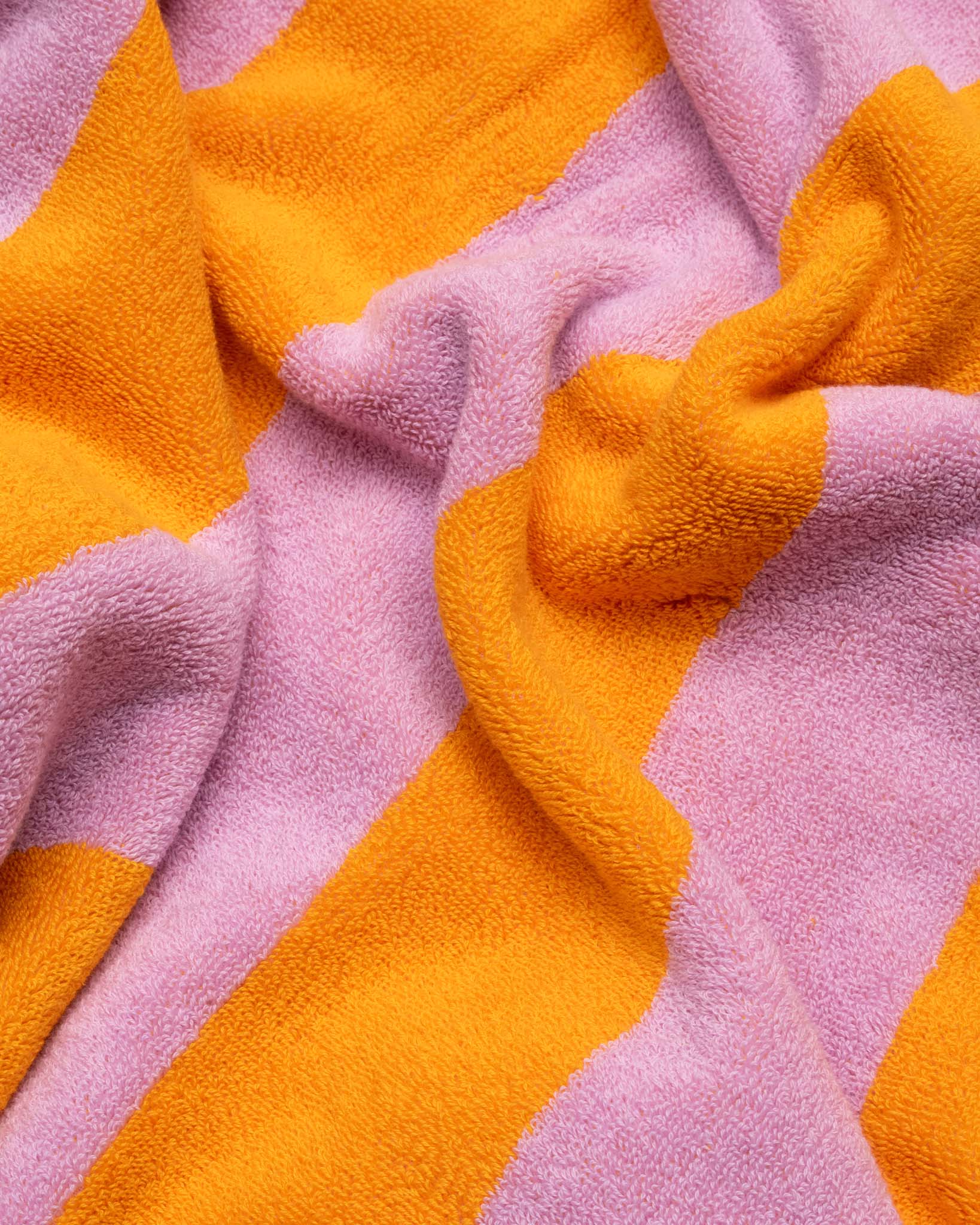 A wrinkled pink and orange striped towel. 