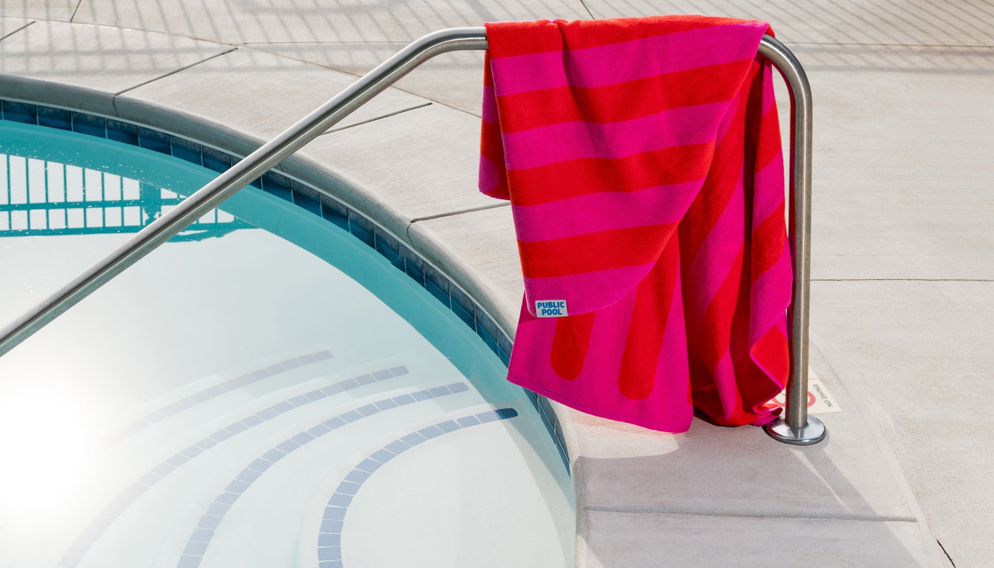 A towel hanging from pool railing.