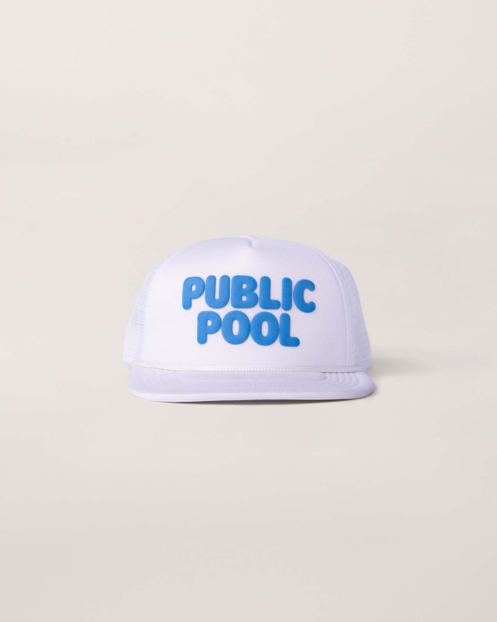 A white trucker hat with an blue Public Pool logo. 